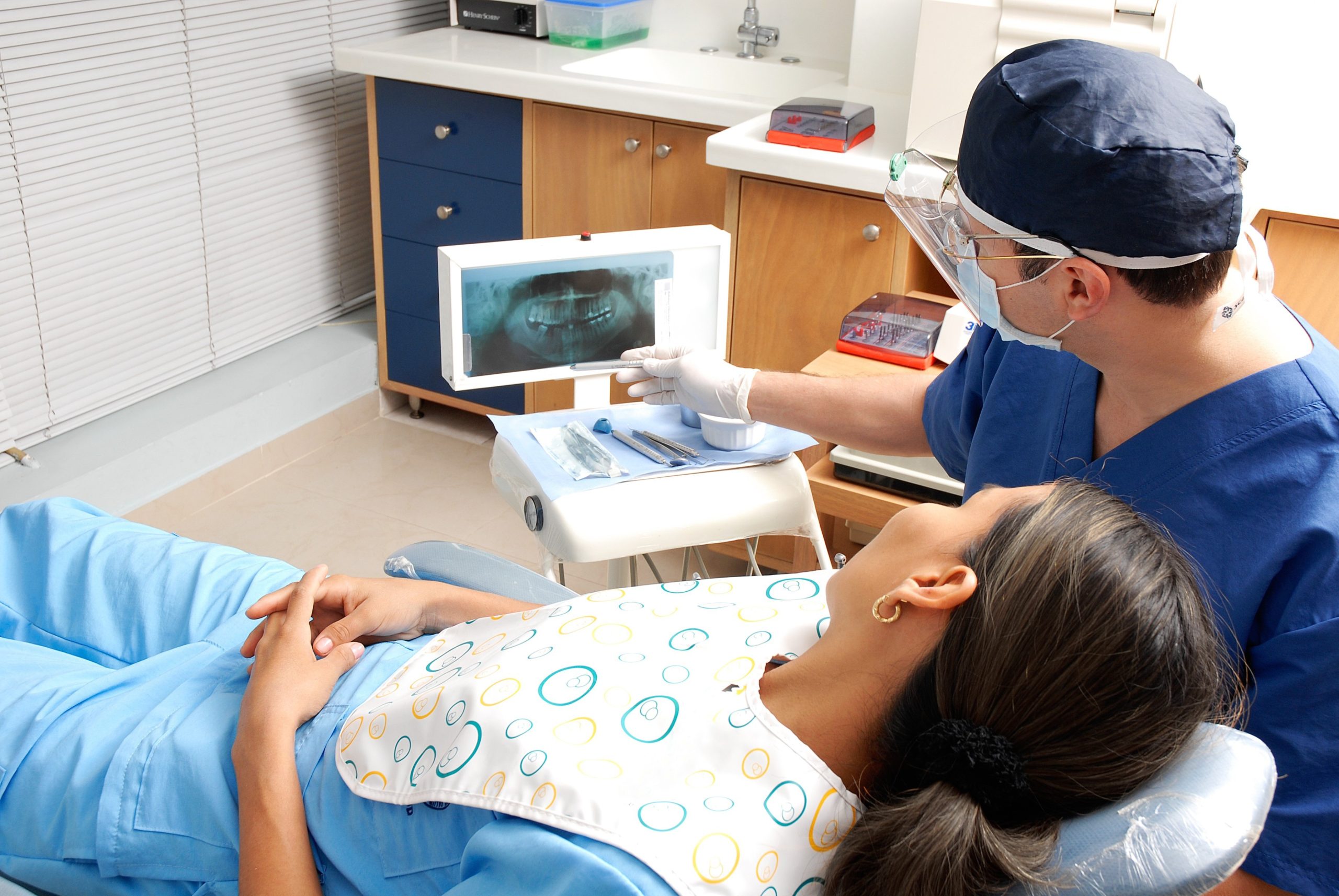 a dentist looking at a patient's x-ray
