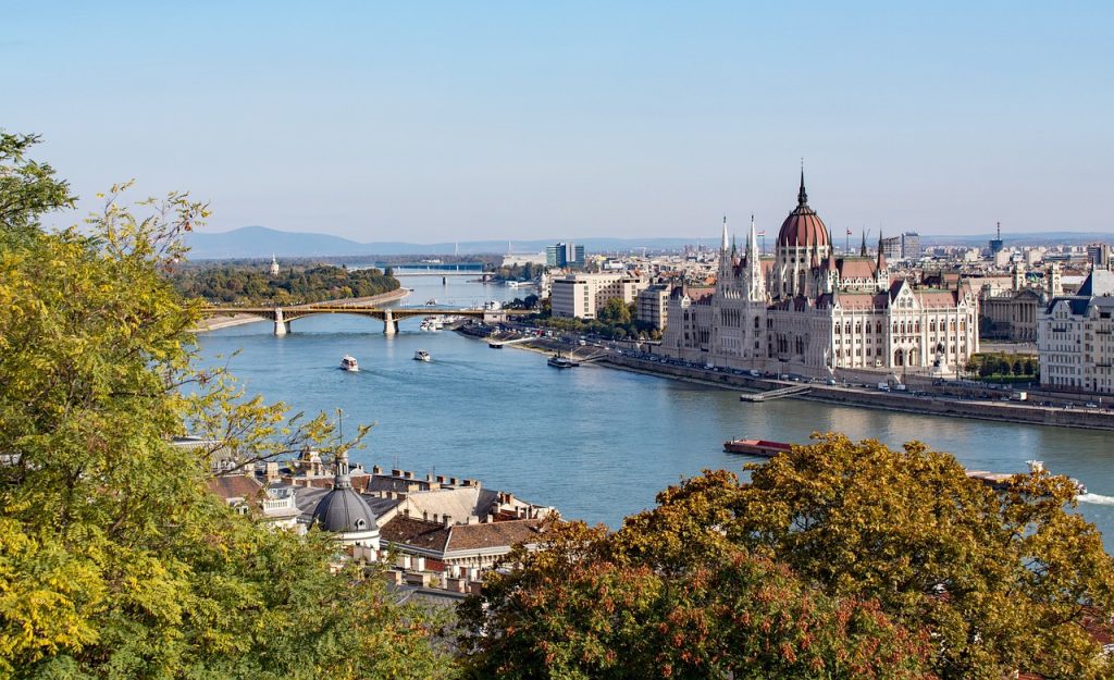 a picture of Budapest from high up - a river with a bridge and a large building